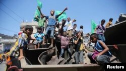 FILE - Palestinian children are seen waving Hamas flags in Khan Younis in the southern Gaza Strip.