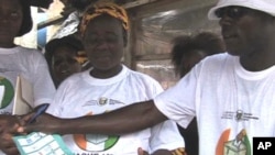 Educators teach female street vendors how to properly fold a ballot after marking their candidate so the ink will not smudge into multiple boxes, rendering the vote invalid
