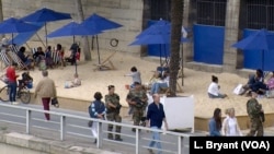 Soldiers patrolling Paris Plage by the Seine River.