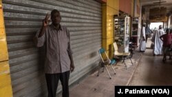 Siddig Ibrahim menunjukkan tanda V (Victory) saat melancarkan aksi mogok dengan menutup tokonya di Khartoum, Sudan, Selasa (28/5). 