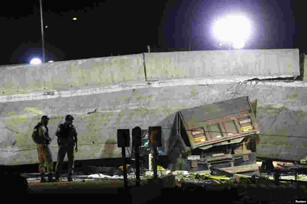 A vehicle is trapped underneath a bridge that collapsed while under construction in Belo Horizonte, July 3, 2014.