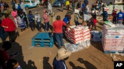 Distribution alimentaire pour les personnes touchées par le ralentissement économique suite à l'épidémie du coronavirus dans le quartier d'Iterileng au sud-ouest de Pretoria, Afrique du Sud, le 20 mai 2020.