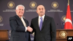 Menteri Luar Negeri Turki Mevlut Cavusoglu, kanan, berjabat tangan dengan Menteri Luar Negeri AS Rex Tillerson, kiri, setelah konferensi pers gabungan setelah pertemuan mereka di Ankara, Turki, 16 Februari 2018.