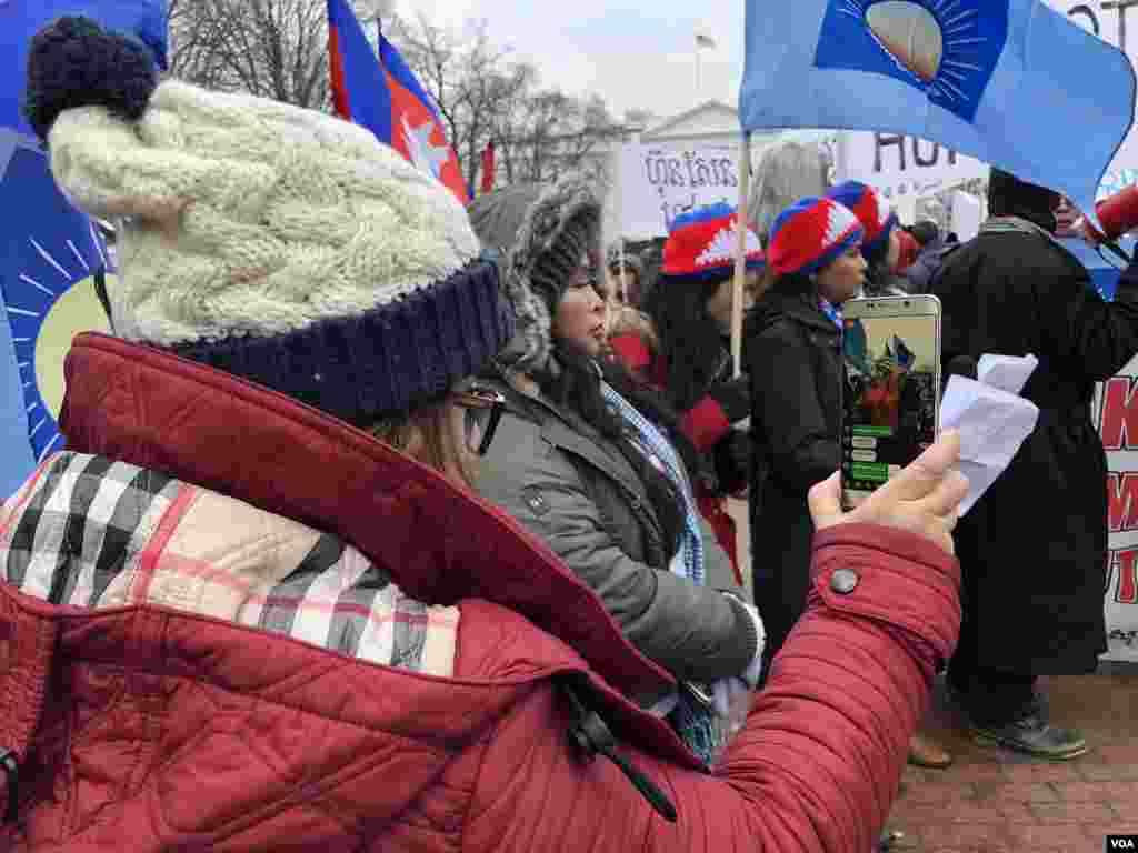 បាតុករថត&nbsp;និងចាក់ផ្សាយព្រឹត្តិការណ៍បាតុកម្មនៅសេតវិមានជាបន្តផ្ទាល់លើបណ្តាញហ្វេសប៊ុក។ (ចាប ចិត្រា/VOA)