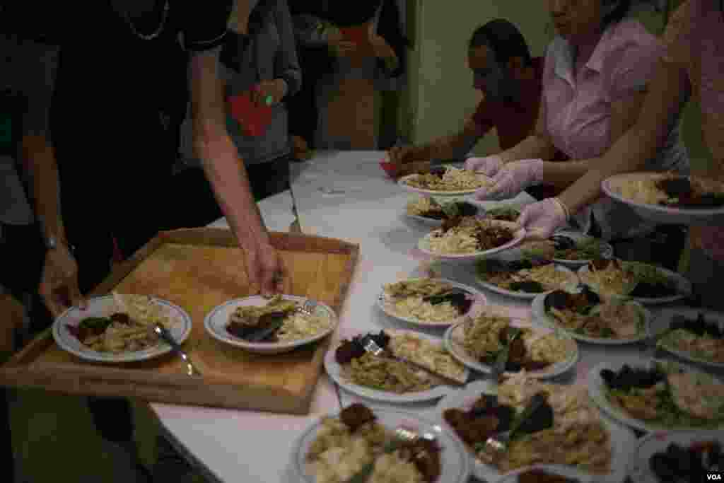 Meals are being served. Both activists and refugees take part in preparing food, much of which is sourced through the activists' network. (J. Owens/VOA)