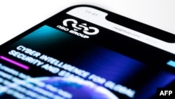 This studio photographic illustration shows a smartphone with the website of Israel's NSO Group which features 'Pegasus' spyware, on display in Paris on July 21, 2021. - Private Israeli firm NSO Group has denied media reports its Pegasus software is…