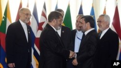 Presiden Iran Mahmoud Ahmadinejad menyambut President Mesir Mohammed Morsi dalam pembukaan KTT Gerakan Non Blok di Teheran (30/8). 