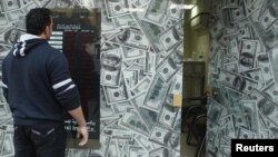 A man stands outside an exchange bureau in Cairo, December 30, 2012.