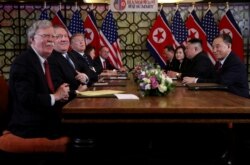 John Bolton, left, and others attend an extended bilateral meeting between North Korea's leader Kim Jong Un and U.S. President Donald Trump, in Hanoi, Vietnam Feb. 28, 2019.