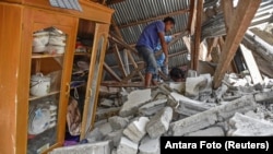 A villager walks through the ruins of a collapsed house during a search for the equipment of Malaysian tourists who died during the earthquake at the Sembalun Selong village in Lombok Timur, Indonesia, July 29, 2018.