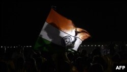 Seorang penonton memegang bendera India setelah Chandrayaan-1, misi Badan Riset Antariksa India untuk meluncurkan satelit, dibatalkan karena masalah teknis di Sriharikota, India, 15 Juli 209.
