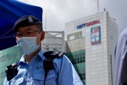 A police officer stands guard outside the Apple Daily headquarters on Thursday, June 17, 2021. (AP/Kin Cheung)
