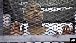 Mohammed Fahmy, penjabat kepala biro stasiun televisi Al-Jazeera, tampil dalam sidang di pengadilan Kairo, Juni 2014.