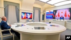 블라디미르 푸틴 러시아 대통령이 모스크바 관저에서 레제프 타이이프 에르도안(오른쪽 화면) 터키 대통령과 화상 통화하고 있다. (자료사진)