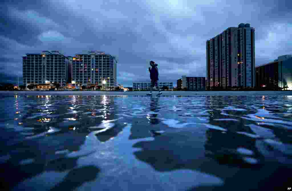 佛罗伦萨飓风逼近美国南卡罗来纳州的默特尔海滩，拉斯&middot;刘易斯在沙滩上寻找贝壳。