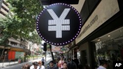 FILE - A Chinese yuan sign is seen at a currency exchange shop in Hong Kong, Aug. 11, 2015. 