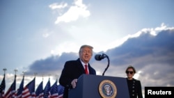 U.S. President Donald Trump speaks next to first lady Melania Trump as he departs from the Joint Base Andrews, Maryland, Jan. 20, 2021. 