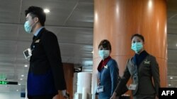 រូបឯកសារ៖ បុគ្គលិកផ្នែកហោះហើរពាក់ម៉ាសការពារនៅព្រលានយន្តហោះក្រុងយ៉ាងហ្គន កាលពីថ្ងៃទី២៤ ខែកុម្ភៈ ឆ្នាំ២០២០។ 