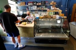 Karyawan James Lawrence melayani pelanggan di supermarket Replenish di Ann Arbor (AP Photo/Paul Sancya)