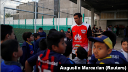 Eduardo David Rodriguez, 40, gives instructions to children at a soccer school he manages for hobby, in Lomas de Zamora, on the outskirts of Buenos Aires, Argentina September 28, 2021. . (REUTERS/Agustin Marcarian)