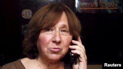 Svetlana Alexievich speaks on the phone as she walks out of her apartment in Minsk, Belarus, Oct. 8, 2015.
