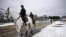Mounted police ride past a security fence in Washington, DC, on January 18, 2025, as the US capital prepares for the inauguration of US President-elect Donald Trump January 20. (Photo by ANDREW CABALLERO-REYNOLDS / AFP)