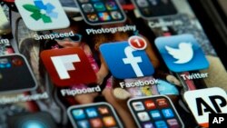FILE - An iPhone with Twitter, Facebook and other apps, May 21, 2013. U.S. internet companies are taking a harder look at their policies that have promoted free expression around the world.