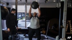 Seorang remaja berlatih olahraga bersama pelatihnya di sebuah pusat kebugaran di Los Angeles pada 13 Maret 2023. (Foto: AP/Jae C. Hong)