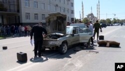 Dans cet enregistrement vidéo fourni par la télévision russe RU-RTR, les enquêteurs inspectent une voiture qui aurait été utilisée pour attaquer la police dans Grozny, en Russie, le 20 août 2018.