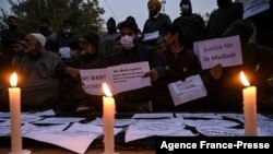 Family members of two civilians who died during a search operation by government forces demand, along with others, justice and the return of the bodies of their loved ones, during a protest in Srinagar, Indian-administered Kashmir, Nov. 17, 2021.