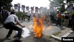 A man from an anti-North Korea and conservative civic group burns an effigy of North Korean leader Kim Jong Un during an anti-North Korean rally near the demilitarized zone separating the two Koreas in Paju, South Korea, August 11, 2015.