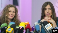 Two members of Russian punk group Pussy Riot, Nadezhda Tolokonnikova (R) and Maria Alyokhina (L), answer journalists' questions during their news conference in Moscow on December 27, 2013. 