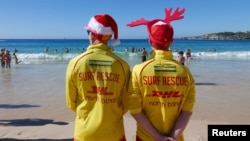 FILE - Volunteer life guards from North Bondi Surf Life Saving Club, keep an eye on swimmers enjoying Christmas day on Bondi Beach, Sydney, Dec. 25, 2018. Australia sweated through one of its hottest Decembers ever, and January wasn't any better.