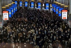 Crowds wearing protective masks, following an outbreak of the coronavirus, are seen at the Shinagawa station in Tokyo, Japan.