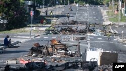 A street is blocked by debris and burnt items following overnight unrest in the Magenta district of Noumea in France's Pacific territory of New Caledonia on May 18, 2024.