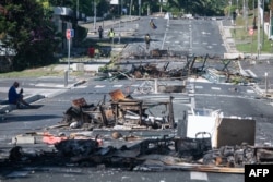 Sebuah jalan dipenuhi puing-puing dan barang-barang yang hangus terbakar menyusul kerusuhan semalaman di distrik Magenta, Kaledonia Baru, 18 Mei 2024. (Foto: Delphine Mayeur/AFP)