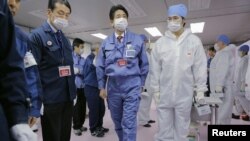 Japan's new prime minister, Shinzo Abe (C), tours the emergency operations center of the crippled Fukushima nuclear power plant December 29, 2012.