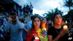 Anti-government demonstrators hold candles during a vigil in honor of those who have been killed during clashes between security forces and demonstrators in Caracas, Venezuela, Monday, July 31, 2017.