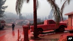 Sebuah mobil di jalanan yang disirami bahan pemadam kebakaran di Lake Elsinore, California, 10 Agustus 2018. 