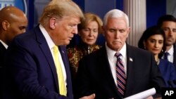 President Donald Trump gestures for Vice President Mike Pence to speaks in the briefing room of the White House in Washington, March 9, 2020, about the coronavirus outbreak.