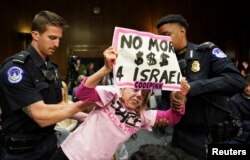 Policija izvodi demonstrantkinu iz sale senatskog odbora tokom svjedočenja sekretara za odbranu Lloyda Austina i državnog sekretara Antonyja Blinkena, 31. oktobra 2023. (Foto: Rojters/Kevin Lamarque)