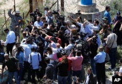 A Hezbollah officer, who identified himself as Ehab, top left, explains to journalists about the defensive measures established by the Israeli forces to prevent against any Hezbollah infiltration into Israel, at Labbouneh, south Lebanon, April 20, 2017.