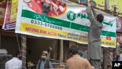 FILE - Volunteers help out at a bakery to provide bread on a subsidized rate to needy people during the government-imposed nationwide lockdown to help curb the spread of the coronavirus, in Islamabad, Pakistan, April 15, 2020.