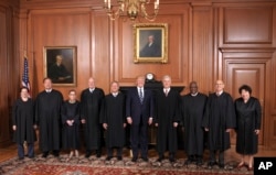 In this image provided by the Supreme Court, President Donald Trump poses with members of the Supreme Court, June 15, 2017, at the court in Washington.