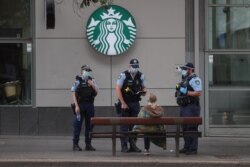 Police officers speak with a member of the public during a law enforcement operation to prevent anti-lockdown protesters from gathering during a lockdown to curb the spread of the COVID-19 in Sydney, Australia, July 31, 2021.