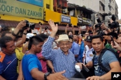 Malaysia former Prime Minister Mahathir Mohamad, center, waves to activists from the Coalition for Clean and Fair Elections (BERSIH) on his arrival during a rally in Kuala Lumpur, Malaysia, Aug. 30, 2015.