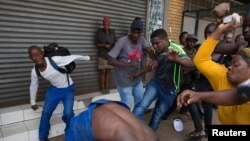 A vigilante mob attacks a Nigerian migrant outside a church in Pretoria, South Africa, Feb. 18, 2017. 