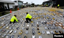 Colombian anti-narcotics policemen inspect packs of cocaine at the police base in Necocli, Feb. 24, 2015.