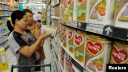 Seorang penjaga toko membantu seorang pelanggan untuk mencari produk susu di sebuah toko di Hefei, provinsi Anhui (Foto: dok). 