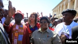 Morgan Tsvangirai, à gauche, chef du mouvement pour le changement démocratique du Zimbabwe (MDC), une main levée, marche aux côtés du leader du Zimbabwe People (ZIMPF), Joice Mujuru, ancien vice-président du Zimbabwe, lors d'une manifestation contre La mauvaise gestion de l'économie du président Robert Mugabe à Gweru, le 13 août 2016. 